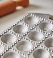 Close-up view of the cupped depressions in the empty ravioli mold