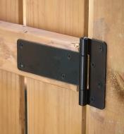 A plain tee hinge installed on a wooden gate