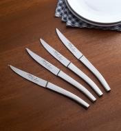 A set of four Le Thiers bistro knives with plates and napkins on a dining table