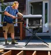A man uses the SawStop 10" Compact Table Saw to cut a board