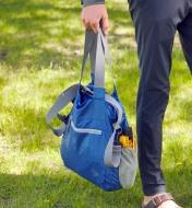 A  packable shoulder bag being held by the handles