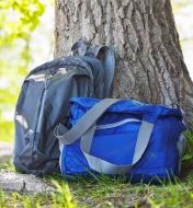 A packable backpack and a packable shoulder bag against a tree