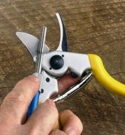 Using the 280x diamond polycrystalline sharpener to sharpen the blade of the bypass pruner