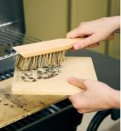 Using the toolshed brush to clean a barbecue pizza stone