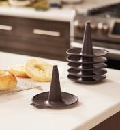Five stacked bagel molds in the background and one in the foreground on a countertop