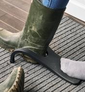 A booted foot positioned in the opening of the black jack boot jack