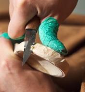Carving the side of the spoon with the sloyd knife