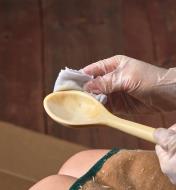 Applying the finish on a carved spoon