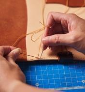 Sewing the leather journal cover with the waxed thread