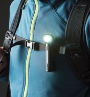 A flashlight clipped to a backpack strap
