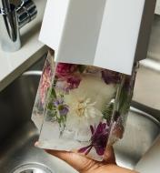 Removing an ice lantern with flowers frozen inside from the mold
