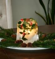 Holiday ice lantern decorated with holly, pine branches and pine cones 