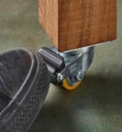A foot pressing down on the brake on a caster