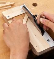 Using the miniature shooting plane and board with a 45° angled block to trim a miter