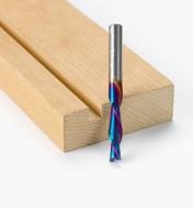 A 1/4 inch diameter downcut bit next to a board with a groove cut into it