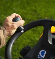 A riding mower being steered by a knob connected to the steering wheel