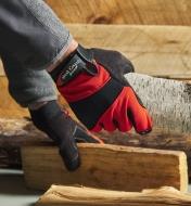 Wearing work gloves while picking up wooden logs
