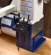 A rear-mounted holder on a lathe holds two spindle-locking wrenches and a knockout bar
