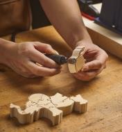 Using the flex shaft to smooth the edges of a wooden puzzle piece