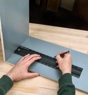 Registering the end of an 18" shop rule against an inside wall of a cabinet carcass