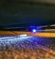 The LED light on the grabber illuminates an object under furniture