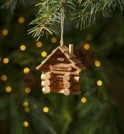 The assembled log cabin ornament hanging on a Christmas tree
