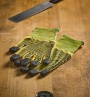 Cut-resistant gloves and a dovetail saw resting on a workbench top