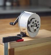 The X-Acto KS pencil sharpener mounted on a board that is clamped to a horizontal surface