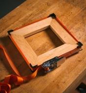 A web clamp around a square frame on a workbench