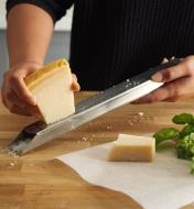 Grating cheese on a stainless- steel rasp with zester holder