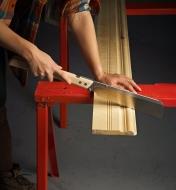 Using a folding dozuki to cut a piece of baseboard