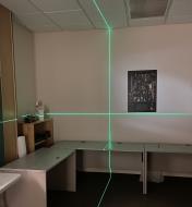 A crosshair laser level aimed at a wall also shines onto the perpendicular walls, floor and ceiling