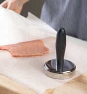 Covering meat with waxed paper in readiness for flattening using the meat pounder