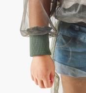 A close-up view of a full-width rib-knit wrist cuff on a hooded bug-protection shirt worn by a child