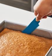 Sliding the bakeware buddy knife around a cake’s edges to detach it from the pan
