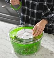 Pulling the retractable cord on a salad spinner