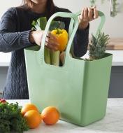 A woman fills the go-anywhere tote with fresh produce