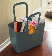 The go-anywhere tote filled with beach items rests on a floor