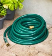 A hose coiled on patio stones.