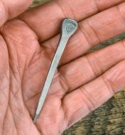 A #10 horseshoe nail lying in the palm of a person’s hand