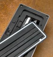 A close-up of the cover that seals the motion-activated light's mode switch and battery compartment