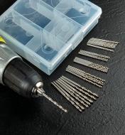 A set of 30 HSS drill bits beside the included storage case, with one of the bits chucked in a drill