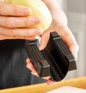 Affixing a potato to the hand guard of the V-slicer prior to slicing