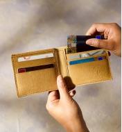 Placing a card in one of the six card pockets of the tree leather classic billfold wallet