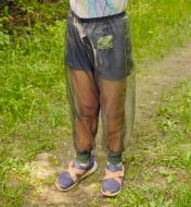 A child wears a pair of bug-protection pants on a hiking trail