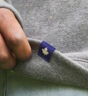 Close-up of maple leaf tag sewn onto bottom of sweatshirt