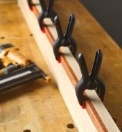 Four Plastic Spring Clamps holding a workpiece on a workbench