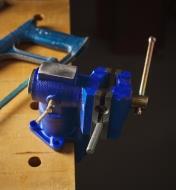 An articulating vise clamped to a workbench