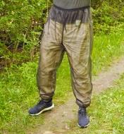 A man wears a pair of bug-protection pants on a hiking trail