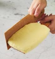Personne moulant une brique de beurre frais à l'aide de palettes à beurre